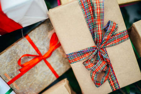 Extensive series of holiday shots with a variety of props and backgrounds. Lots of copyspace for ads. Christmas presents on wooden table. A couple of gifts wrapped in Christmas themed wrapping paper.の写真素材