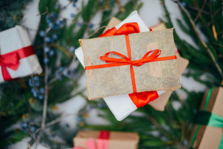Extensive series of holiday shots with a variety of props and backgrounds. Lots of copyspace for ads. Christmas presents on wooden table. A couple of gifts wrapped in Christmas themed wrapping paper.の写真素材