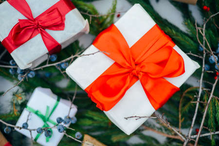Extensive series of holiday shots with a variety of props and backgrounds. Lots of copyspace for ads. Christmas presents on wooden table. A couple of gifts wrapped in Christmas themed wrapping paper.の写真素材