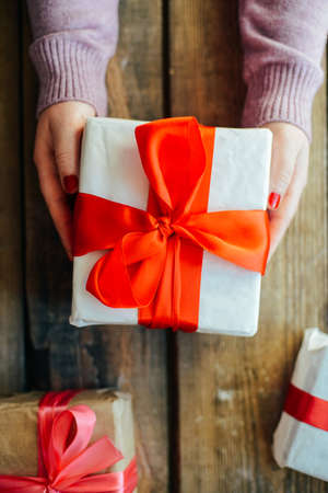 Valentine's Day concept. Gift with red bow  on the wooden background, Valentines. Valentines gift boxes tied with a red satin ribbon bow on  background. gift on , wedding dayの写真素材
