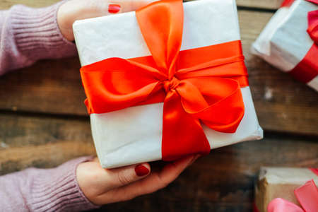 Valentine's Day concept. Gift with red bow  on the wooden background, Valentines. Valentines gift boxes tied with a red satin ribbon bow on  background. gift on , wedding dayの写真素材