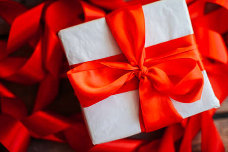 Valentine's Day concept. Gift with red bow  on the wooden background, Valentines. Valentines gift boxes tied with a red satin ribbon bow on  background. gift on , wedding dayの写真素材