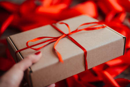 Valentine's Day concept. Gift with red bow  on the wooden background, Valentines. Valentines gift boxes tied with a red satin ribbon bow on  background. gift on , wedding dayの写真素材