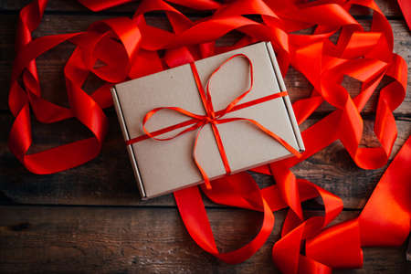 Valentine's Day concept. Gift with red bow  on the wooden background, Valentines. Valentines gift boxes tied with a red satin ribbon bow on  background. gift on , wedding dayの写真素材