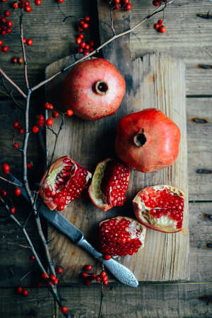Fresh red pomegranate and grapefruit On a wooden background. Pomegranate in  plate on  wood...
