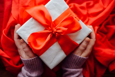 Valentine's Day concept. Gift with red bow  on the wooden background, Valentines. Valentines gift boxes tied with a red satin ribbon bow on  background. gift onの写真素材