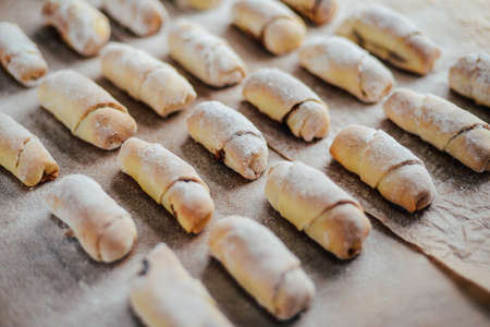 Vanilla crescents before baking. Vanilla rolls. Roll pastry cookie. sliced rolls of dough roll.  cookie dough on a parchment paper, selective focusの写真素材