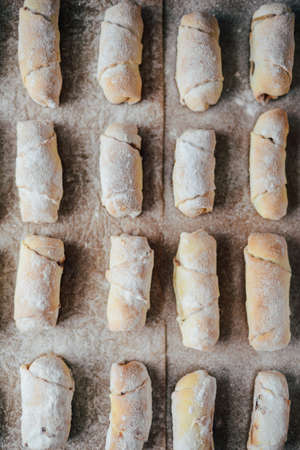 Vanilla crescents before baking. Vanilla rolls. Roll pastry cookie. sliced rolls of dough roll.  cookie dough on a parchment paper, selective focusの写真素材