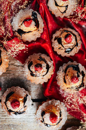 Delicious chocolate cupcakes with berries on wodeen table, top view. Homemade Chocolate Cupcake with...