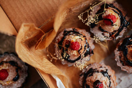 Delicious chocolate cupcakes with berries on wodeen table, top view. Homemade Chocolate Cupcake with chocolate frosting against a background. colorful cupcakesの写真素材