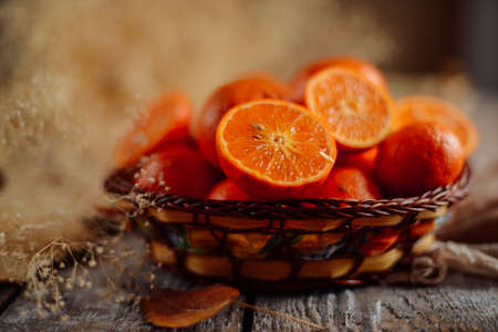 Basket of Tangerines on a wooden table.  Delicious and beautiful Tangerines.  Citrus background.  Mandarins Tangerine Closeup. Rustic styleの写真素材
