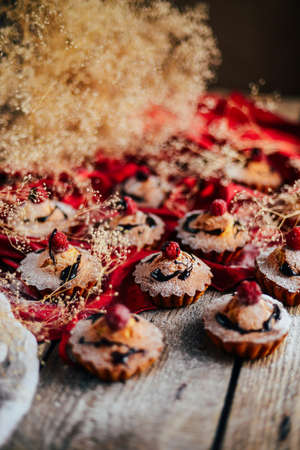 Delicious chocolate cupcakes with berries on wodeen table, top view. Homemade Chocolate Cupcake with chocolate frosting against a background. colorful cupcakesの写真素材