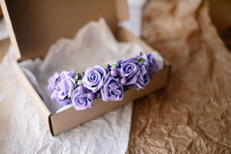 Handmade floral tiara made of  flowers lie on  wooden background. Fashionable hand made wreath of flowers head wear. Hand crafted fashion accessories for womenの写真素材