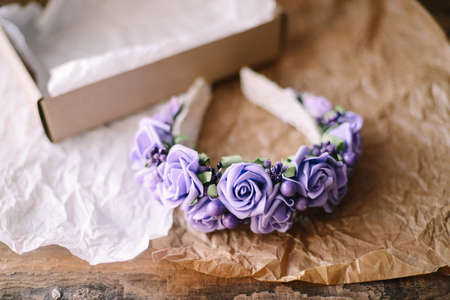 Handmade floral tiara made of  flowers lie on  wooden background. Fashionable hand made wreath of flowers head wear. Hand crafted fashion accessories for womenの写真素材
