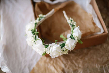 Handmade floral tiara made of  flowers lie on  wooden background. Fashionable hand made wreath of flowers head wear. Hand crafted fashion accessories for womenの写真素材