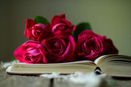 Red roses on wooden vintage table with copy space