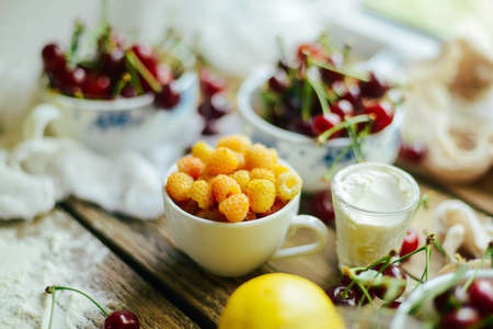Ingredients for baking croissants - flour, wooden spoon, rolling pin, eggs, egg yolks, butter served on wooden background.の写真素材