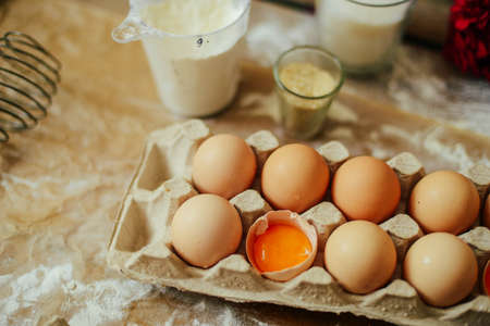 hands cut cookie from raw dough on a wooden table. Healthy baking ingredients - flour,  butter,...