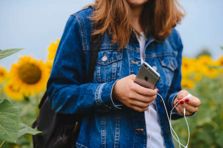 UKRAINE, KYIV - JULY 28, 2017:hipster female holding smart phone similar to iphone6s outdoor lifestyle. Close up of women's hands holding cell telephone. new modern people lifestyleのeditorial素材
