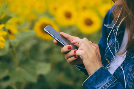 hipster female holding smart phone similar to iphone6s outdoor lifestyle. Close up of women's hands holding cell telephone. new modern people lifestyleの写真素材