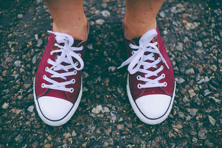 Fashion hipster cool woman with pink sneakers. Close up summer bright image of woman feet, wearing casual bight hipster, posing at city. Closeup of woman posing in sneakers.の写真素材