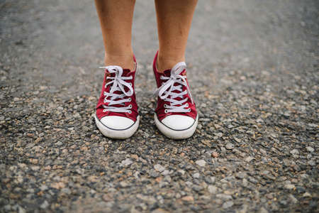 Fashion hipster cool woman with pink sneakers. Close up summer bright image of woman feet, wearing casual bight hipster, posing at city. Closeup of woman posing in sneakers.の写真素材