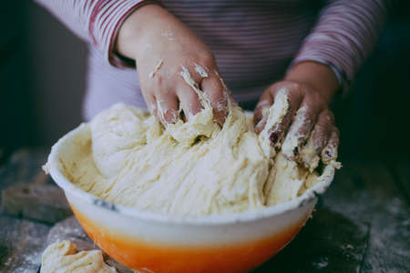 Close up view of baker kneading dough. Homemade bread. Hands preparing bread dough on wooden table. Preparing traditional homemade bread. Woman hands kneading fresh dough for making breadの写真素材