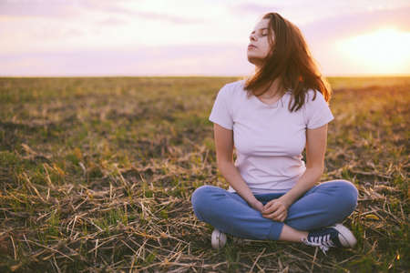 Young woman relaxing in summer sunset sky outdoor. People freedom style.の写真素材