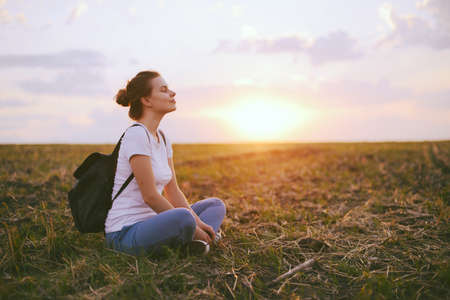 Young woman relaxing in summer sunset sky outdoor. People freedom style.の写真素材