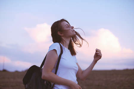 Young woman relaxing in summer sunset sky outdoor. People freedom style.