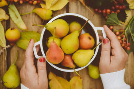 season, drink and morning concept - close up of tea cup on wooden table with autumn leaves and pearの写真素材