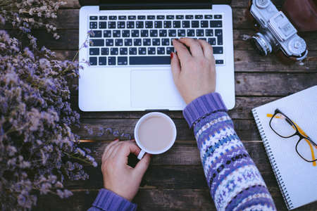 Woman working at home office hand on keyboard close up