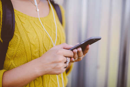 pretty hipster girl in the summer city with smartphone