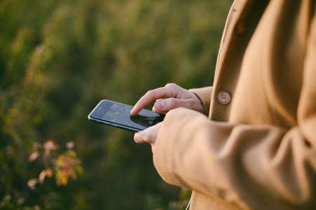 Beautiful young woman using smart phone outdoorの写真素材