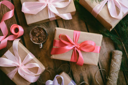 Lots of Gift boxes on wooden background. Presents in craft  paper decorated with  ribbon. Christmas and other holidays concept.の写真素材