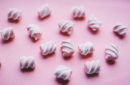 Marshmallows on pink background . Flat lay or top view. Background or texture of colorful mini marshmallows. Winter food background concept.の写真素材