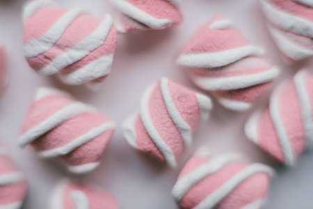 Marshmallows on pink background . Flat lay or top view. Background or texture of colorful mini marshmallows. Winter food background concept.の写真素材