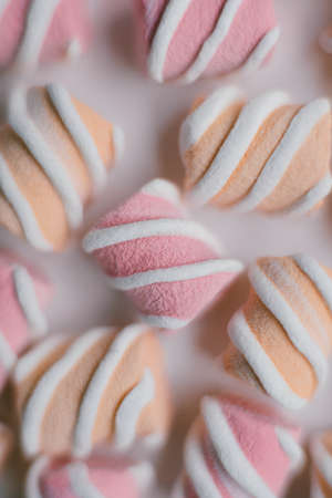 Marshmallows on pink background . Flat lay or top view. Background or texture of colorful mini marshmallows. Winter food background concept.の写真素材