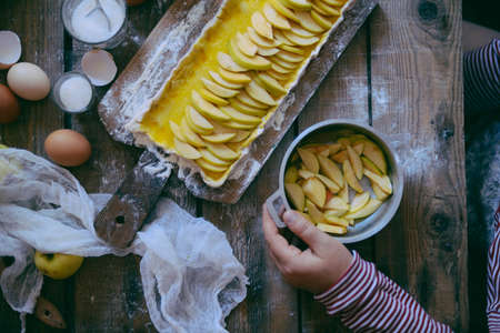 Woman cooking apple pie. Woman cooking apple pie. Traditional dessert for Independence Day. Dark food photo. Rustic style.の写真素材