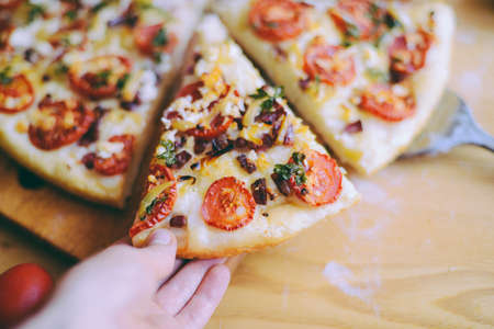  Margherita pizza with utensils and vegetable on slate plate.  Fresh pizza with tomatoes and basil on table closeup. の写真素材