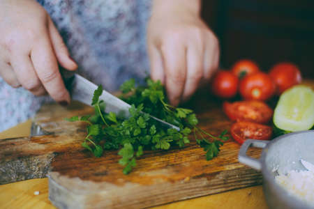 Raw pizza with sauce and ingredients on wooden table. Fresh o raw pizza, preparation in traditional style. Margherita pizza with utensils and vegetable on slate plateの写真素材