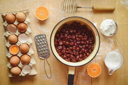 Ingredients for baking - flour, wooden spoon, rolling pin, eggs. Homemade tart pie preparation, dough with yeast and rolling pin on  rustic kitchen tableの写真素材