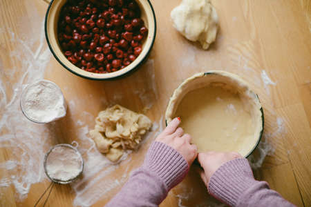Ingredients for baking - flour, wooden spoon, rolling pin, eggs. Woman hands kneading fresh dough の写真素材