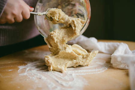 Ingredients for baking - flour, wooden spoon, rolling pin, eggs. Woman hands kneading fresh dough の写真素材