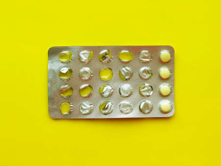 Pills, thermometer on a yellow background, top view. の写真素材