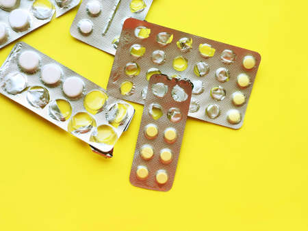 Pills, thermometer on a yellow background, top view. の写真素材