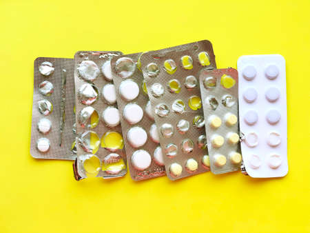 Pills, thermometer on a yellow background, top view. の写真素材