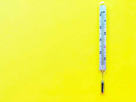 Pills, thermometer on a yellow background, top view. の写真素材