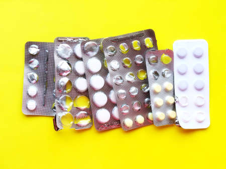 Pills, thermometer on a yellow background, top view. の写真素材