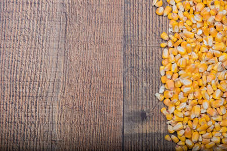 Whole yellow corn bordering side of wood panelの写真素材